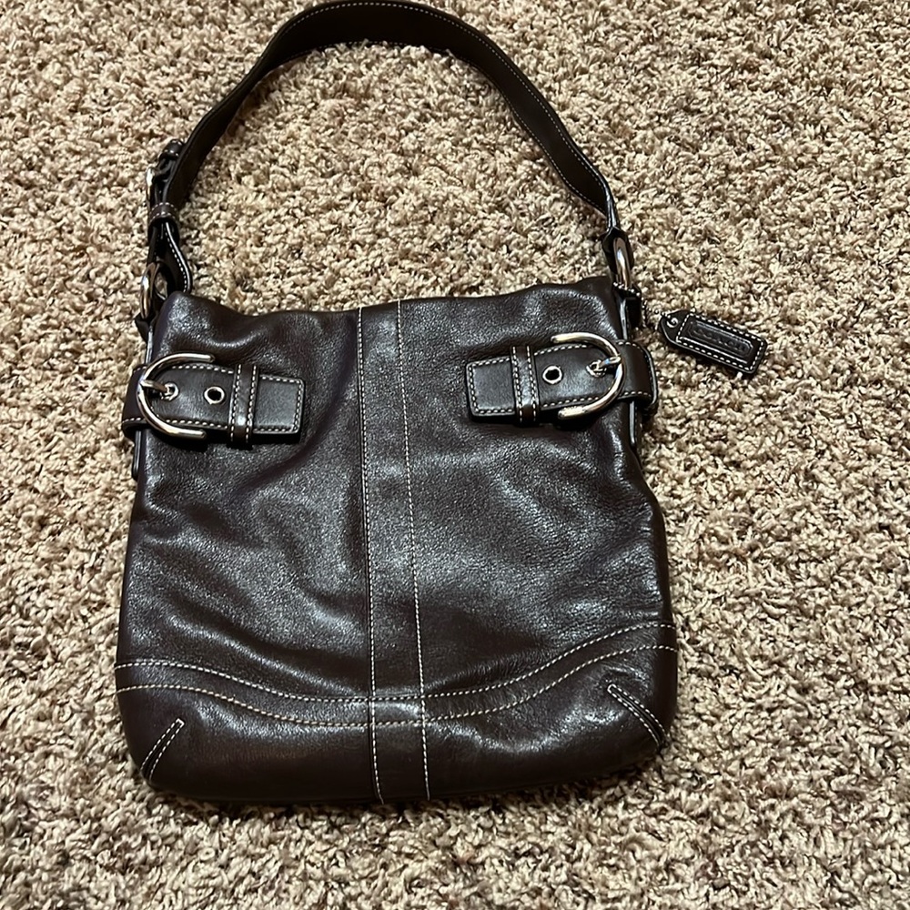 Small brown coach bag with silver detail, and white stitching
